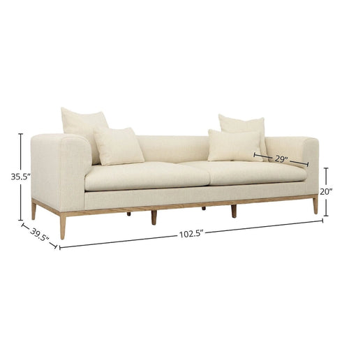 Divano beige imbottito con quattro cuscini