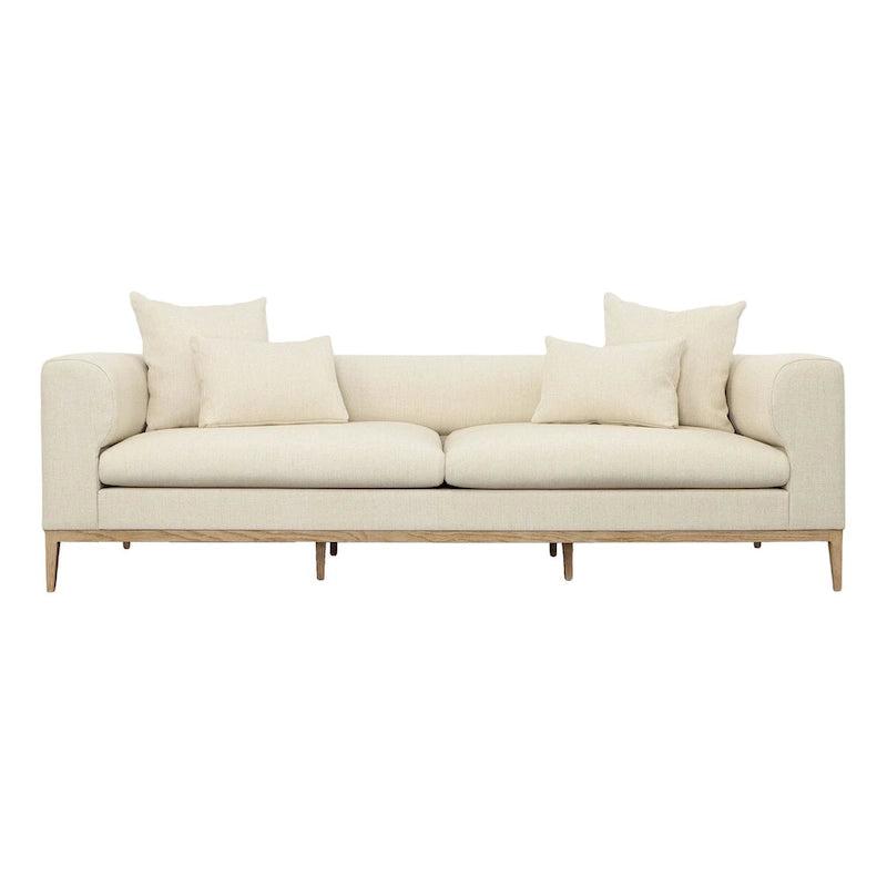 Canapé beige capitonné avec quatre coussins