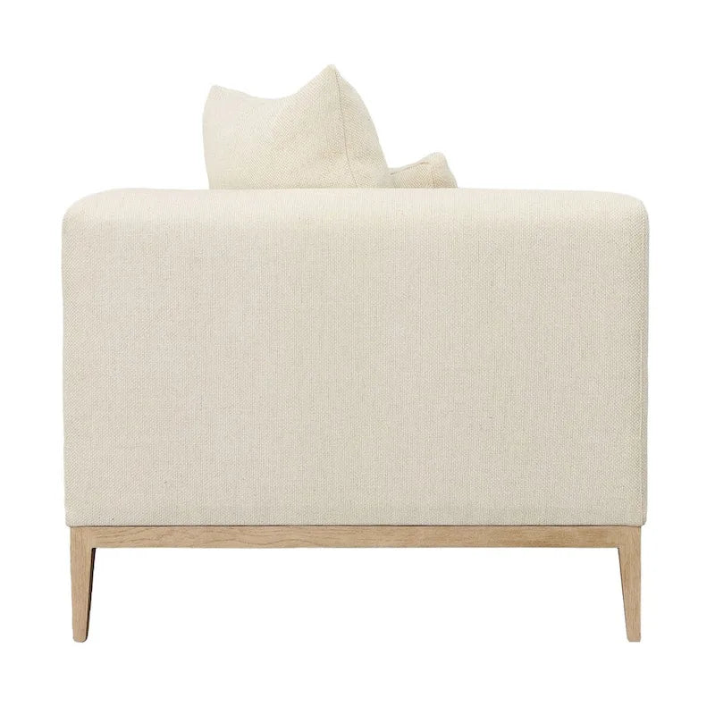 Canapé beige capitonné avec quatre coussins