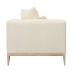 Canapé beige capitonné avec quatre coussins